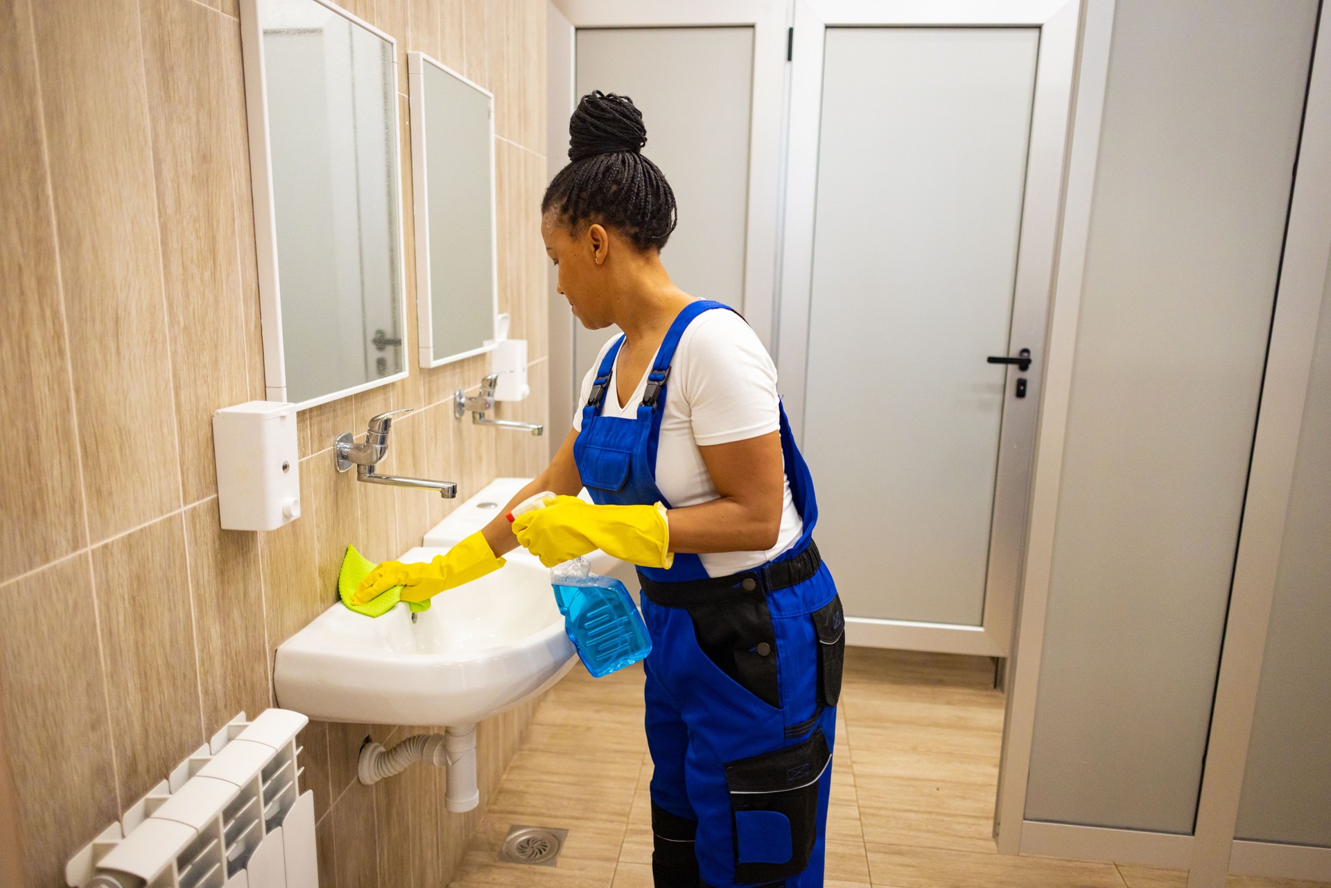 Female janitor cleaning the school toilet